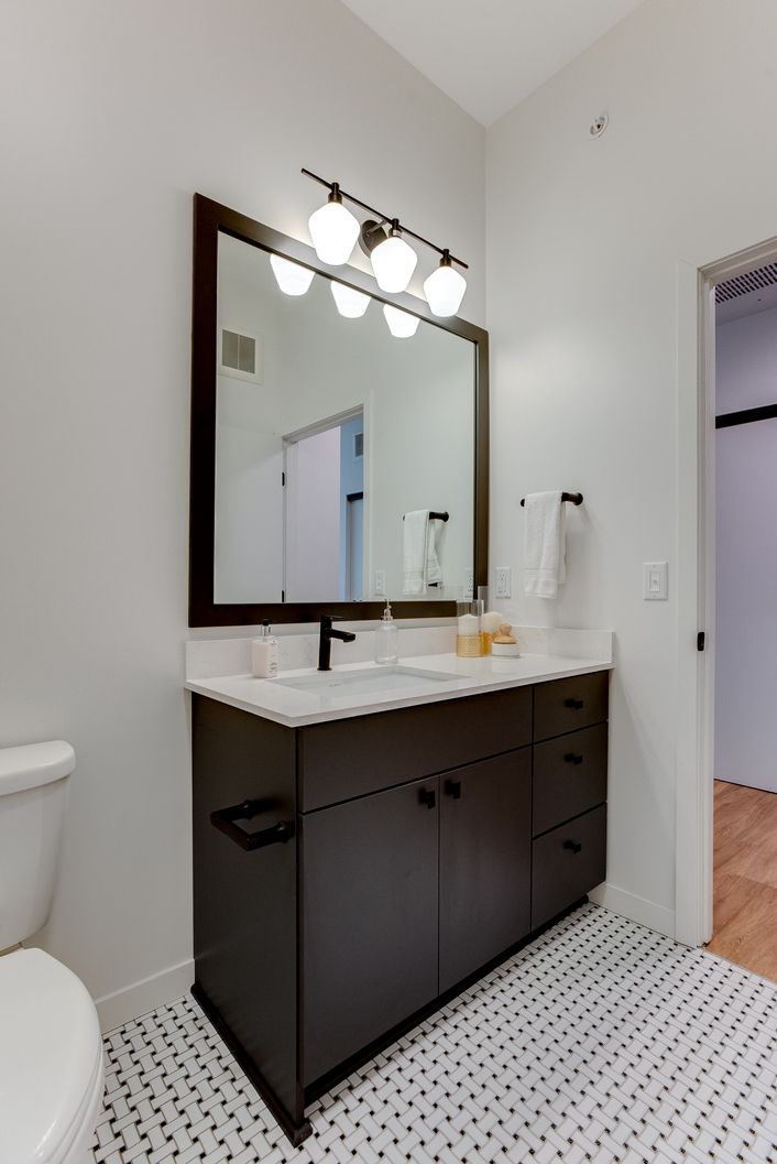 Matte black faucet and oversized vanity mirror.