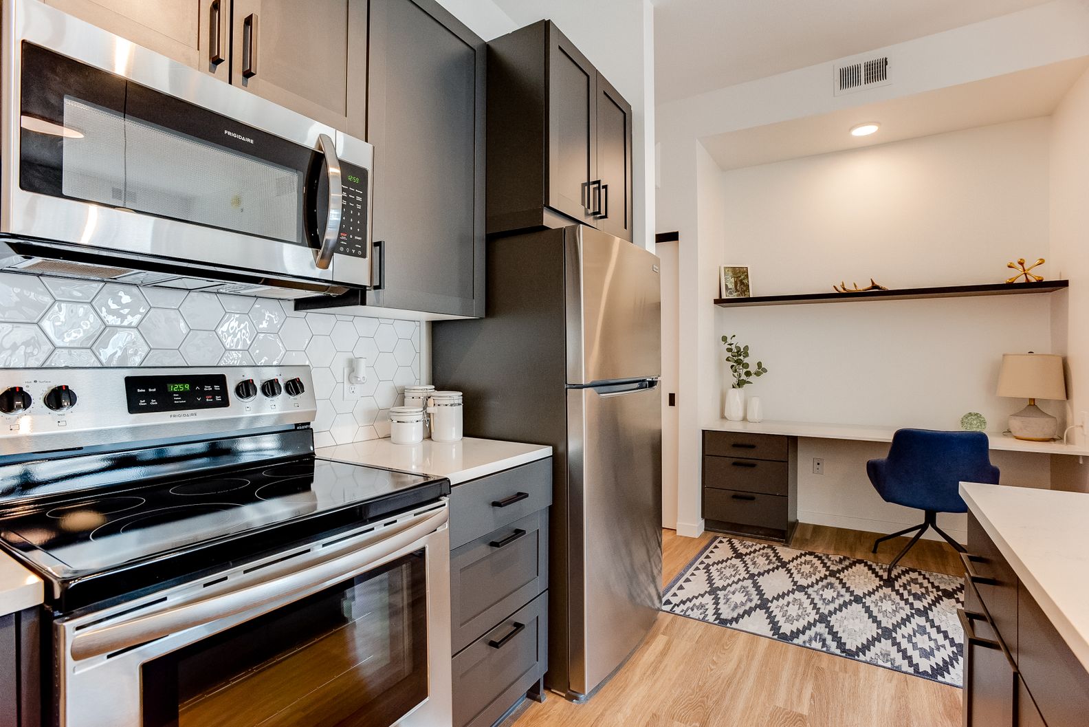 Stainless steel appliances with hex tile backsplash.